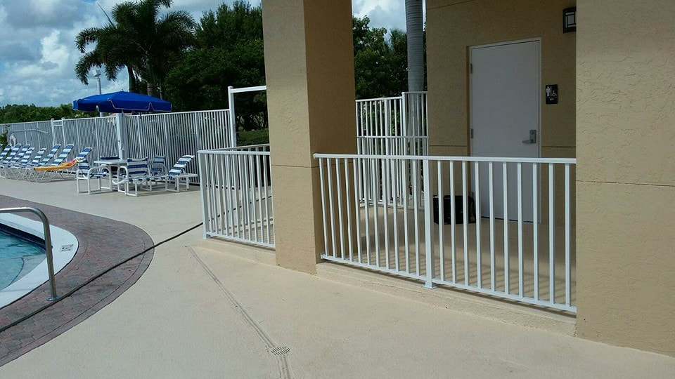 white aluminum security fence around a condo corporation pool